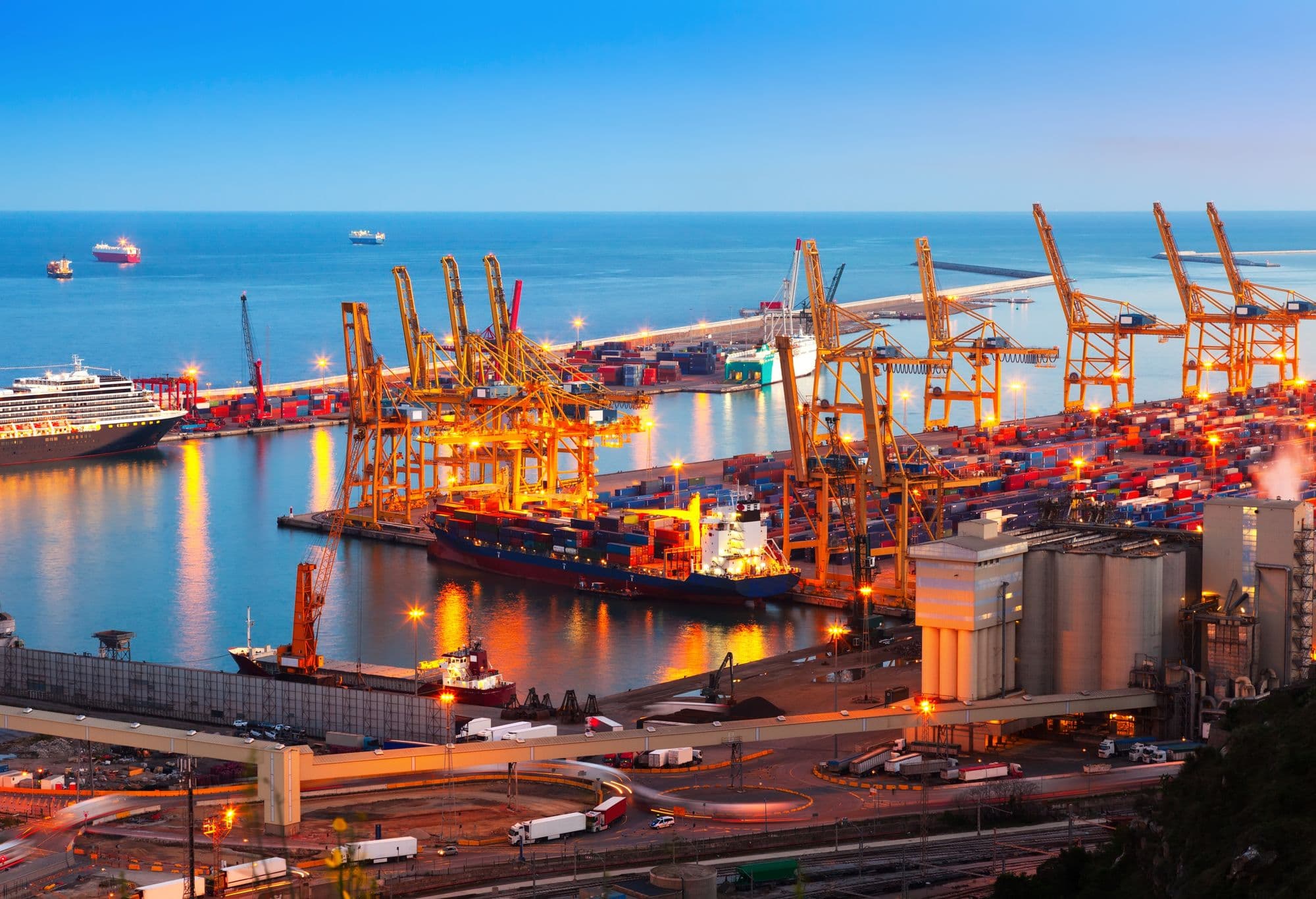 Container port at dusk with cranes loading a cargo ship