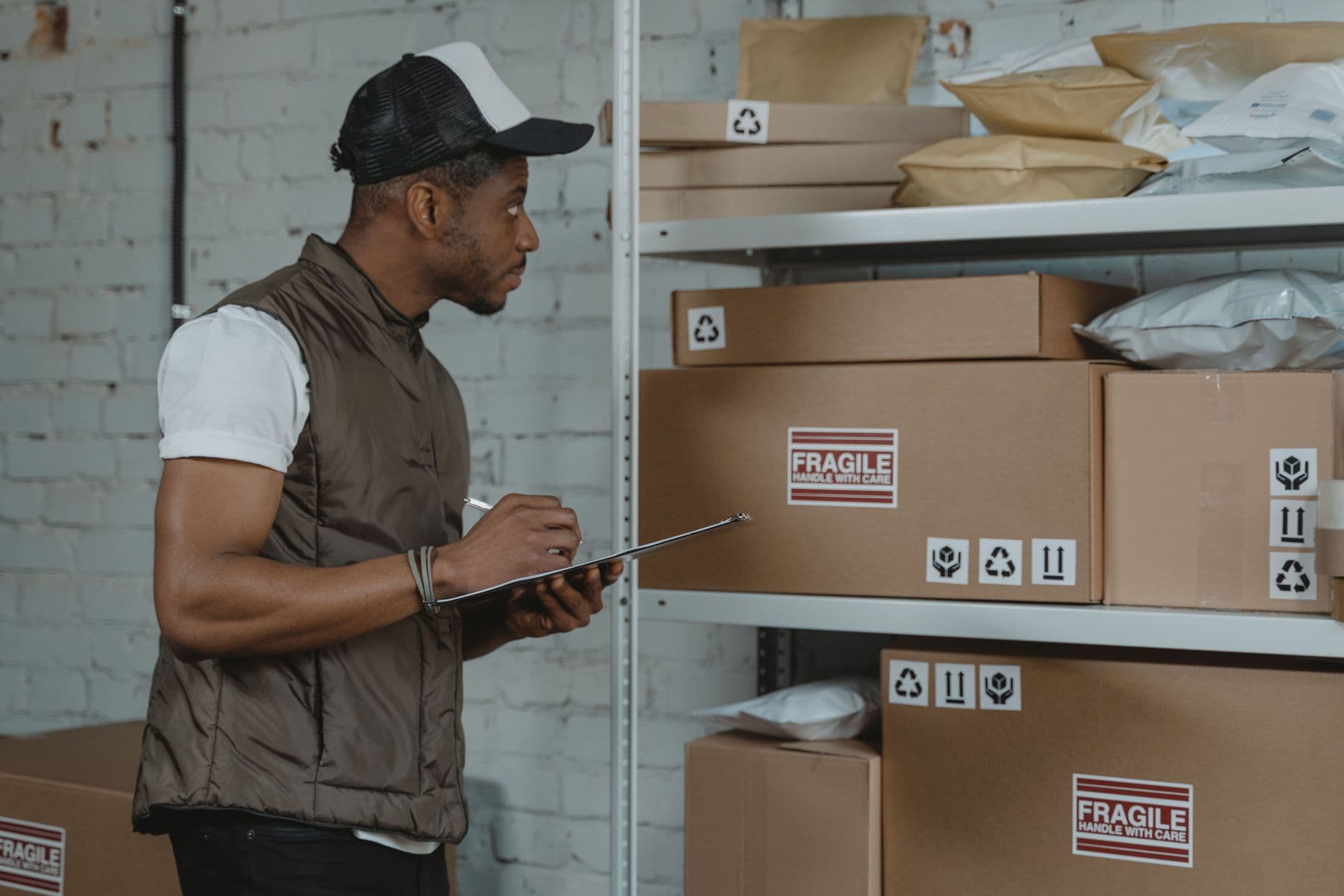 Warehouse worker checking labelled cartons against a clipboard
